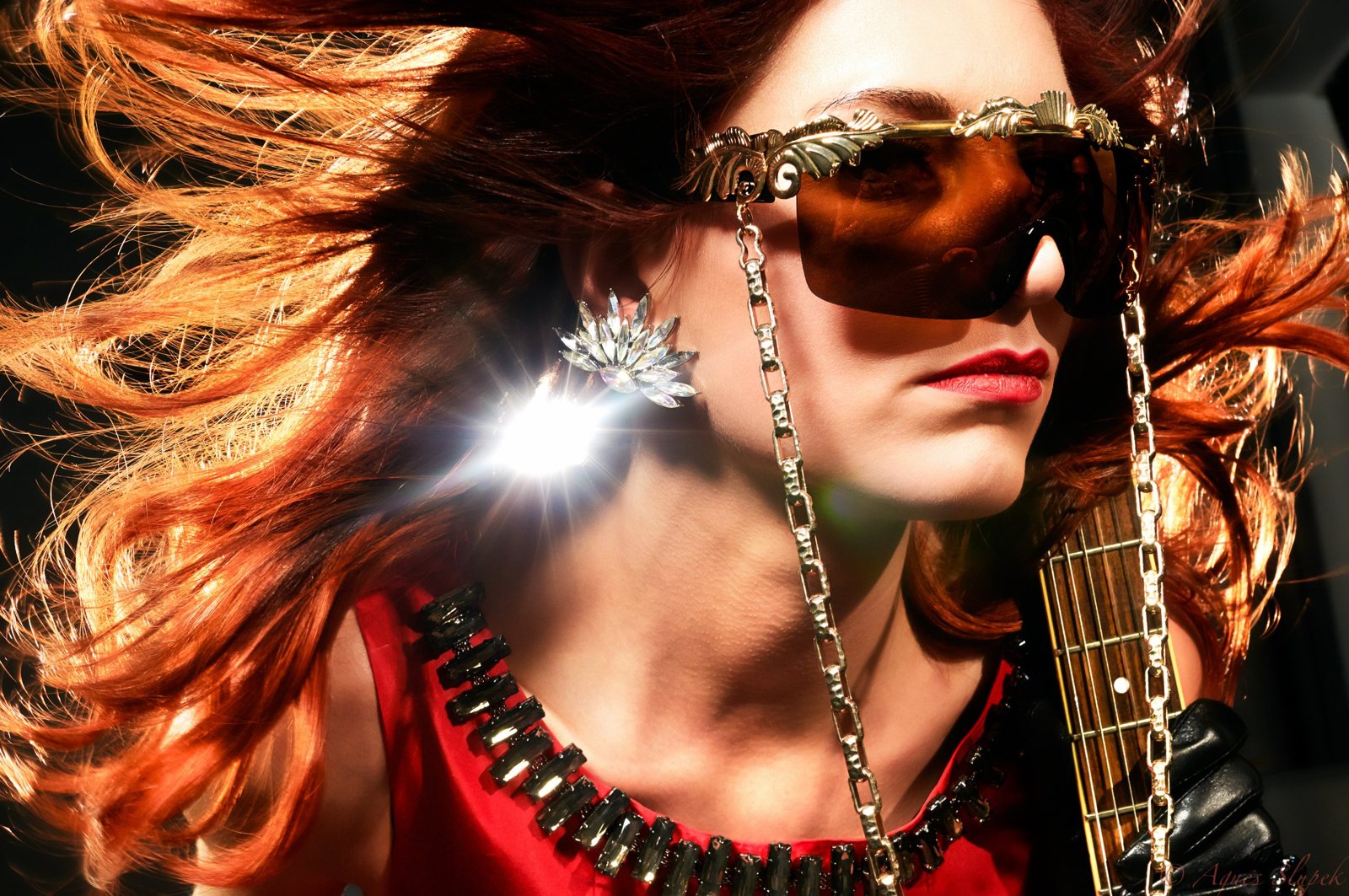 Red hair flying, gold sunglasses and a sparkling earring